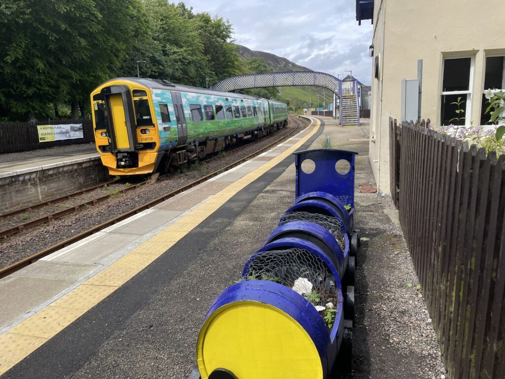 Helmsdale station Friday 14th June. Train leaving for Wick alongside the barrel train planted the same day by local school children.